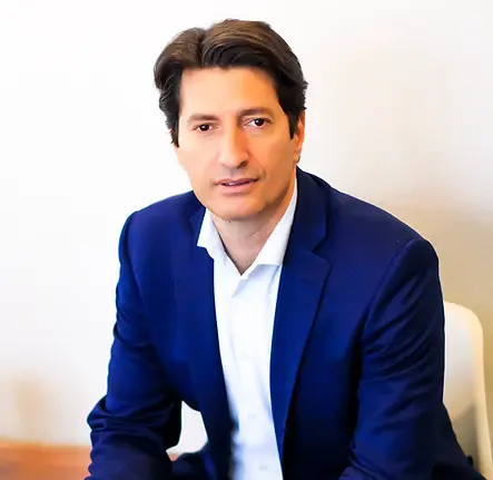 Man in blue suit sitting on chair.
