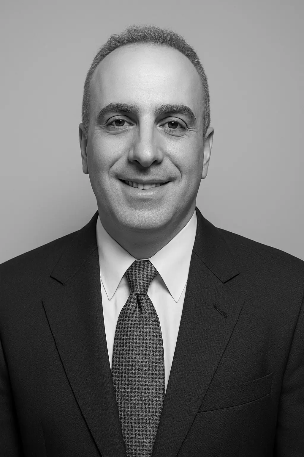 Man in suit and tie, smiling portrait.