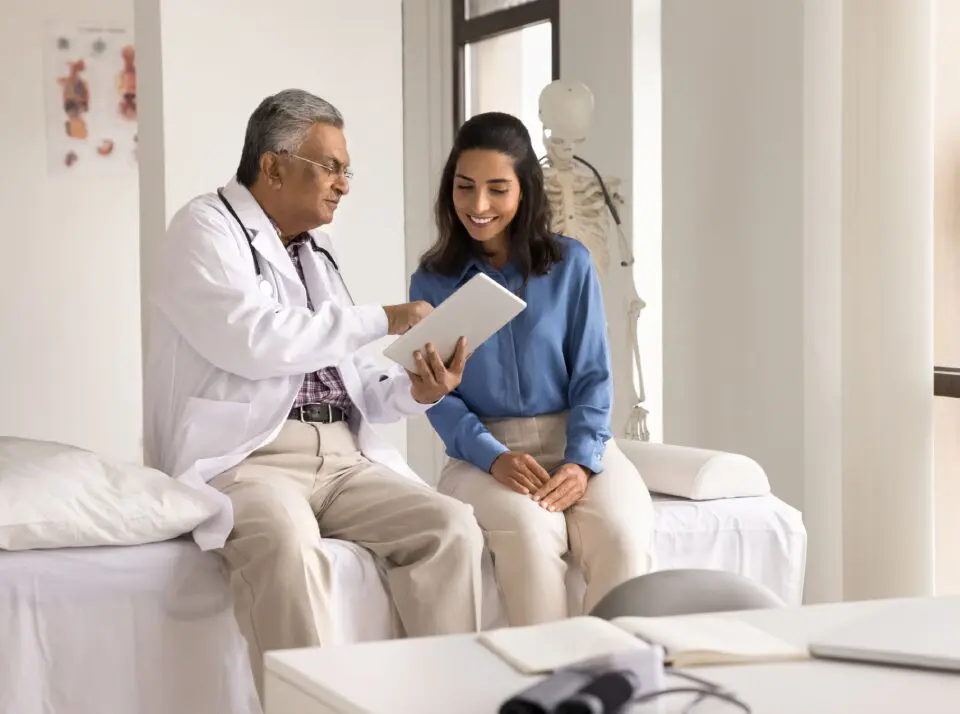 Doctor and patient discussing on tablet.